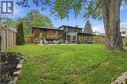 Expansive green lawn with a large mature tree - 