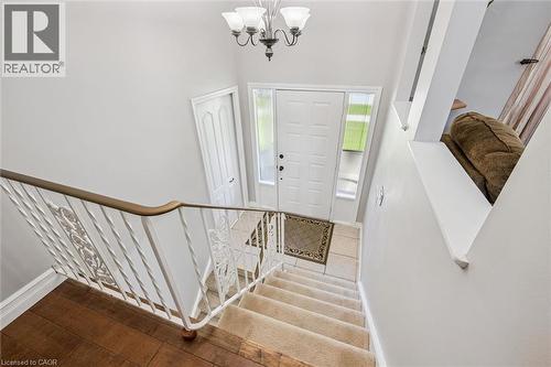 Foyer featuring a white paneled front door with sidelight windows, tile flooring, and a chandelier lighting fixture - 47 Oakhurst Crescent, Kitchener, ON - Indoor Photo Showing Other Room
