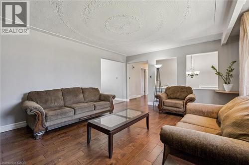 Spacious living area featuring wood-finish flooring, light gray wall tones, and a textured ceiling with decorative patterns - 47 Oakhurst Crescent, Kitchener, ON - Indoor Photo Showing Living Room