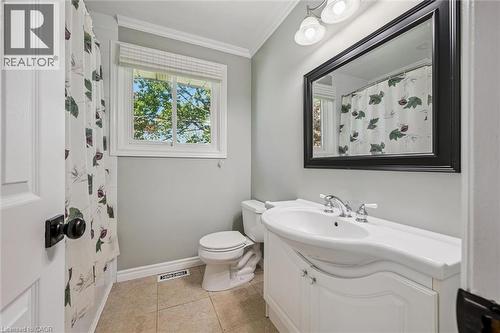 Bathroom featuring a white vanity with integrated sink, chrome faucet, and a wall-mounted mirror with a dark frame - 47 Oakhurst Crescent, Kitchener, ON - Indoor Photo Showing Bathroom