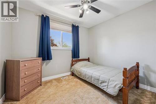 Carpeted room featuring a ceiling fan with integrated lighting, a window with blinds, and white baseboards - 47 Oakhurst Crescent, Kitchener, ON - Indoor Photo Showing Bedroom