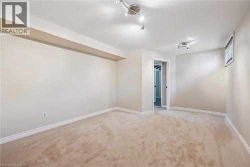newly carpeted room with ensuite, featuring neutral wall tones, white trim, track lighting, and a recessed ceiling beam - 47 Oakhurst Crescent, Kitchener, ON - Indoor Photo Showing Other Room