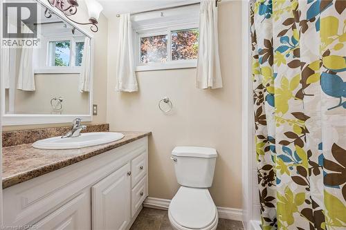 Bathroom featuring a white vanity with a brown speckled countertop, an oval undermount sink, a white framed mirror, and a toilet - 47 Oakhurst Crescent, Kitchener, ON - Indoor Photo Showing Bathroom