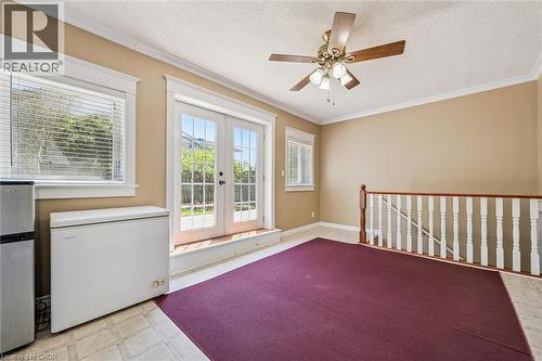 Room featuring French doors, a ceiling fan, crown molding, a window with blinds, and a staircase with a wood railing - 47 Oakhurst Crescent, Kitchener, ON - Indoor Photo Showing Other Room
