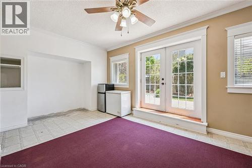 Room featuring glass-paned French doors with white trim, a ceiling fan with light fixture, and two windows with blinds - 47 Oakhurst Crescent, Kitchener, ON - Indoor Photo Showing Other Room