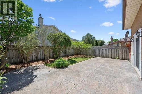 Private backyard featuring a stamped concrete patio, a section of lawn, and perimeter fencing - 47 Oakhurst Crescent, Kitchener, ON - Outdoor