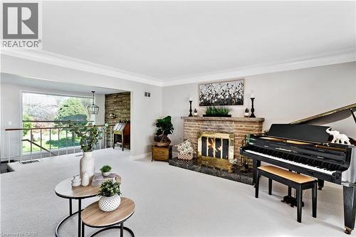 Spacious living area featuring a prominent brick fireplace with a dark stone hearth - 91 Limerick Drive, Kitchener, ON - Indoor Photo Showing Other Room With Fireplace
