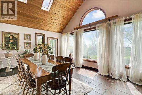 Dining space featuring a vaulted wood-paneled ceiling with skylights, an arched transom window, and a wall of floor-to-ceiling windows - 91 Limerick Drive, Kitchener, ON - Indoor Photo Showing Dining Room
