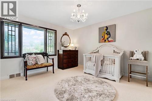 Room featuring light-colored carpet flooring, a chandelier, and a large window with multiple panes and dark trim - 91 Limerick Drive, Kitchener, ON - Indoor Photo Showing Bedroom