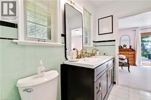 Bathroom featuring a dual-sink vanity with gold-finish fixtures, a white countertop, and dark wood cabinetry - 91 Limerick Drive, Kitchener, ON - Indoor Photo Showing Bathroom