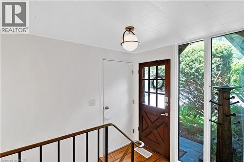 Rustic wood-paneled entry door with glass panes and a metal handle - 91 Limerick Drive, Kitchener, ON - Indoor Photo Showing Other Room