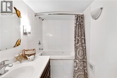 Bathroom featuring a white tile shower surround, built-in bathtub, chrome shower fixture, and a vanity with an undermount sink - 91 Limerick Drive, Kitchener, ON - Indoor Photo Showing Bathroom