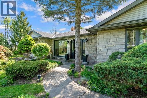 Stone facade residence featuring a covered entry, established landscaping, and a winding concrete pathway - 91 Limerick Drive, Kitchener, ON - Outdoor
