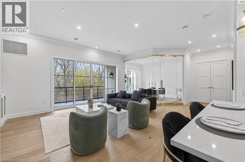 Spacious living area featuring light wood-finish flooring, recessed lighting, and crown molding - 2 Arbourvale Common Unit# 410, St. Catharines, ON - Indoor