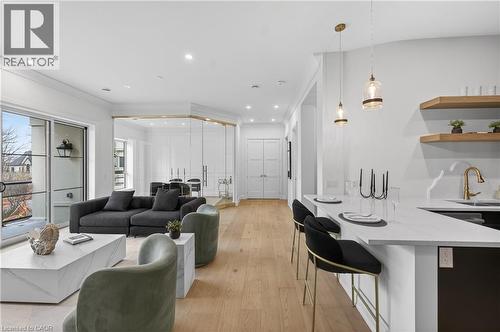 Open-concept living area featuring light wood-finish flooring and recessed lighting throughout - 2 Arbourvale Common Unit# 410, St. Catharines, ON - Indoor