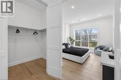 Spacious room with large windows, recessed lighting, crown molding, and wood-finish flooring - 