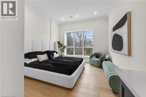 Expansive room featuring light wood-finish flooring, a large window with multiple panes, recessed ceiling lighting, crown molding, and high ceilings - 2 Arbourvale Common Unit# 410, St. Catharines, ON - Indoor