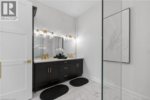 Bathroom featuring a dual vanity with black cabinetry, brass hardware, and a white countertop - 2 Arbourvale Common Unit# 410, St. Catharines, ON - Indoor Photo Showing Bathroom