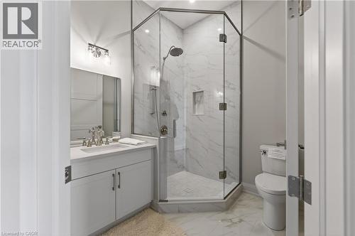 Modern bathroom featuring a glass-enclosed corner shower with full-height tile surround and an integrated niche - 2 Arbourvale Common Unit# 410, St. Catharines, ON - Indoor Photo Showing Bathroom