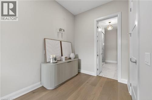 Light wood-finish flooring extending into a spacious hallway - 2 Arbourvale Common Unit# 410, St. Catharines, ON - Indoor Photo Showing Other Room