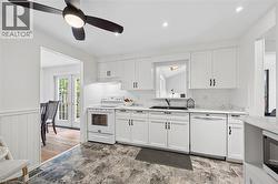 White kitchen featuring shaker-style cabinetry, a built-in range, and a dishwasher - 