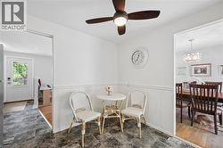 Corner dining nook featuring wainscoting and a ceiling fan with integrated lighting - 