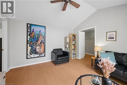 Vaulted ceiling living area featuring light wood-finish flooring, a ceiling fan with wood blades, and light gray wall paint - 50 Lewis Crescent, Kitchener, ON - Indoor