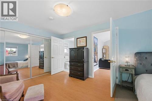 Bedroom featuring wood-finish flooring, mirrored closet doors, and an overhead flush-mount light fixture - 50 Lewis Crescent, Kitchener, ON - Indoor Photo Showing Bedroom