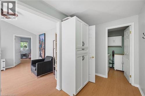 Hallway featuring wood-finish flooring, white walls, and a built-in white storage cabinet with black hardware - 50 Lewis Crescent, Kitchener, ON - Indoor Photo Showing Other Room