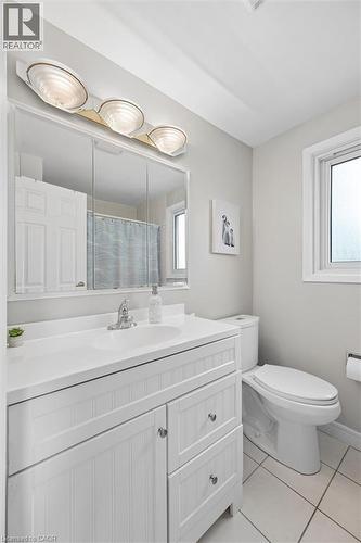 Bathroom featuring a white vanity with beadboard paneling, an integrated sink and countertop, a chrome faucet, and a large wall-mounted mirror - 50 Lewis Crescent, Kitchener, ON - Indoor Photo Showing Bathroom