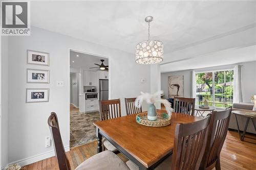 Dining area featuring wood-finish flooring, a contemporary chandelier, and an open doorway to the kitchen - 50 Lewis Crescent, Kitchener, ON - Indoor Photo Showing Dining Room