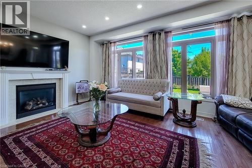 Living area featuring wood-finish flooring, a fireplace with a white mantel, and recessed lighting - 197 Cloverleaf Drive, Ancaster, ON - Indoor Photo Showing Living Room With Fireplace
