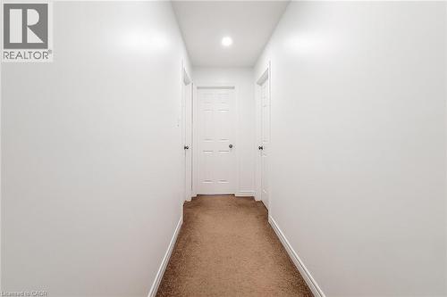 Carpeted hallway featuring white walls and white trim - 197 Cloverleaf Drive, Ancaster, ON - Indoor Photo Showing Other Room