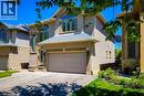 Brick and stone facade residence featuring an integrated two-car garage, arched windows, a covered front entryway, and a paved driveway - 197 Cloverleaf Drive, Ancaster, ON  - Outdoor 