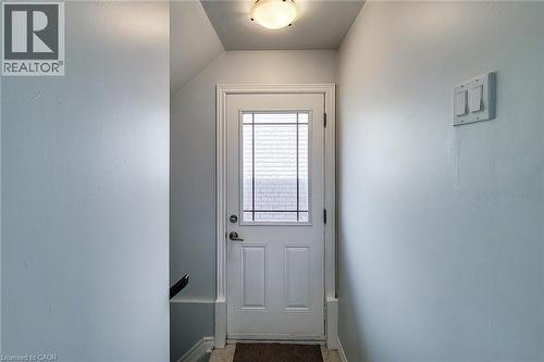 White entry door featuring a multi-pane window insert, a polished door handle, and matching white trim - 197 Cloverleaf Drive, Ancaster, ON - Indoor Photo Showing Other Room