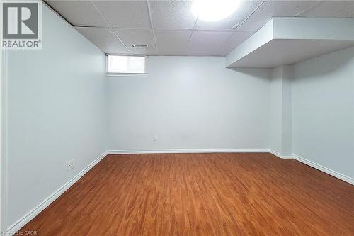 Spacious room featuring wood-finish flooring, white baseboards, and bright white walls - 197 Cloverleaf Drive, Ancaster, ON - Indoor Photo Showing Other Room