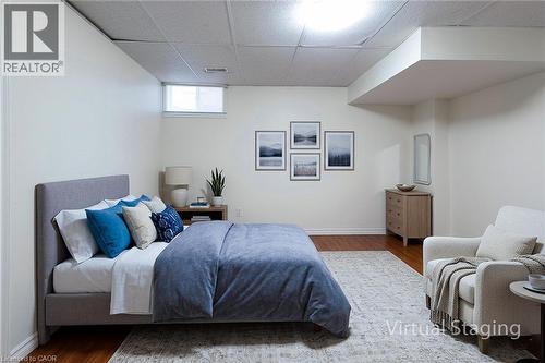 Hardwood-style flooring highlights this spacious room with a drop ceiling and integrated lighting - 197 Cloverleaf Drive, Ancaster, ON - Indoor Photo Showing Bedroom