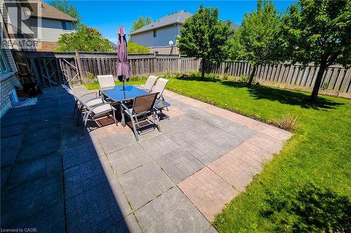 Expansive backyard featuring a large paved patio, a rectangular lawn, and mature perimeter trees - 197 Cloverleaf Drive, Ancaster, ON - Outdoor