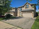 Brick and stone facade residence featuring a two-car garage, arched window accents, and a paved driveway - 197 Cloverleaf Drive, Ancaster, ON  - Outdoor 