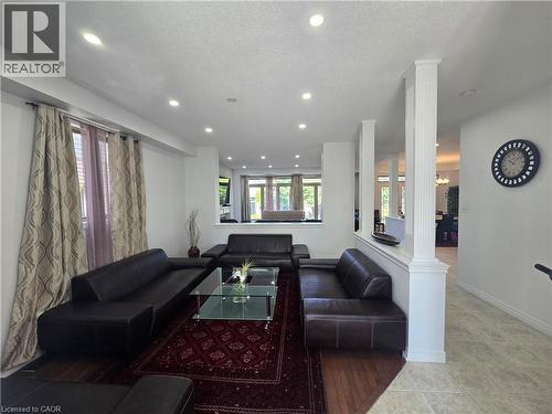 Spacious living area featuring recessed lighting, a combination of wood-finish and tiled flooring, and decorative half-walls with fluted columns - 197 Cloverleaf Drive, Ancaster, ON - Indoor Photo Showing Living Room