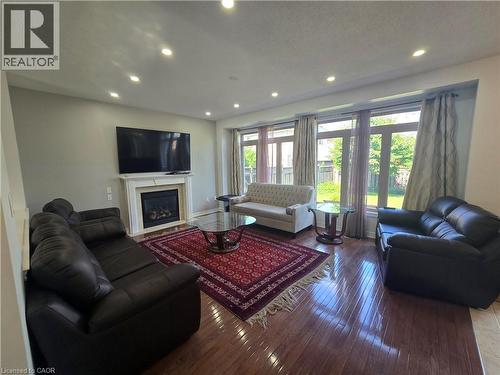 Living space featuring wood-finish flooring, a white mantel fireplace, and recessed ceiling lighting - 197 Cloverleaf Drive, Ancaster, ON - Indoor Photo Showing Living Room With Fireplace