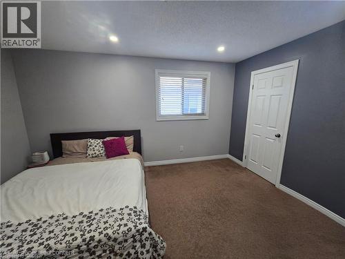 Room featuring recessed lighting, a window with blinds, a paneled door, brown carpeting, and contrasting wall colors - 197 Cloverleaf Drive, Ancaster, ON - Indoor Photo Showing Other Room