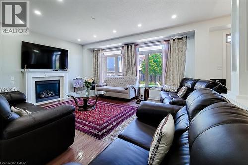 Living area featuring wood-finish flooring, a white mantel fireplace, and recessed lighting - 197 Cloverleaf Drive, Ancaster, ON - Indoor Photo Showing Living Room With Fireplace
