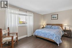 Primary Bedroom with 2 oversized closets Bright interior room with wood-finish flooring, a large window, and light-toned walls - 