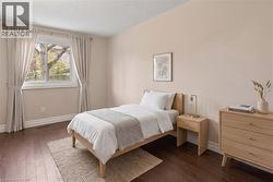 VIRTUALLY STAGED Bedroom 3 featuring wood-finish flooring and a large window - 