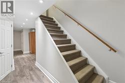 Carpeted staircase with a wood handrail - 