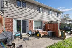 Rear exterior with a concrete patio featuring brick and siding construction, a sliding glass door, and fenced boundaries - 