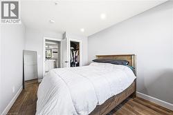 Spacious room featuring wood-finish flooring, light gray walls, white trim, and recessed lighting - 