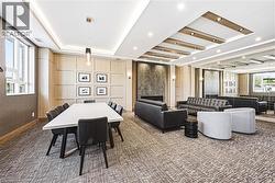 Spacious common area featuring a modern fireplace with a textured surround, recessed lighting, and a mirrored wall panel - 