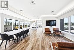 Spacious common area featuring wood-finish flooring, recessed lighting, and large windows - 
